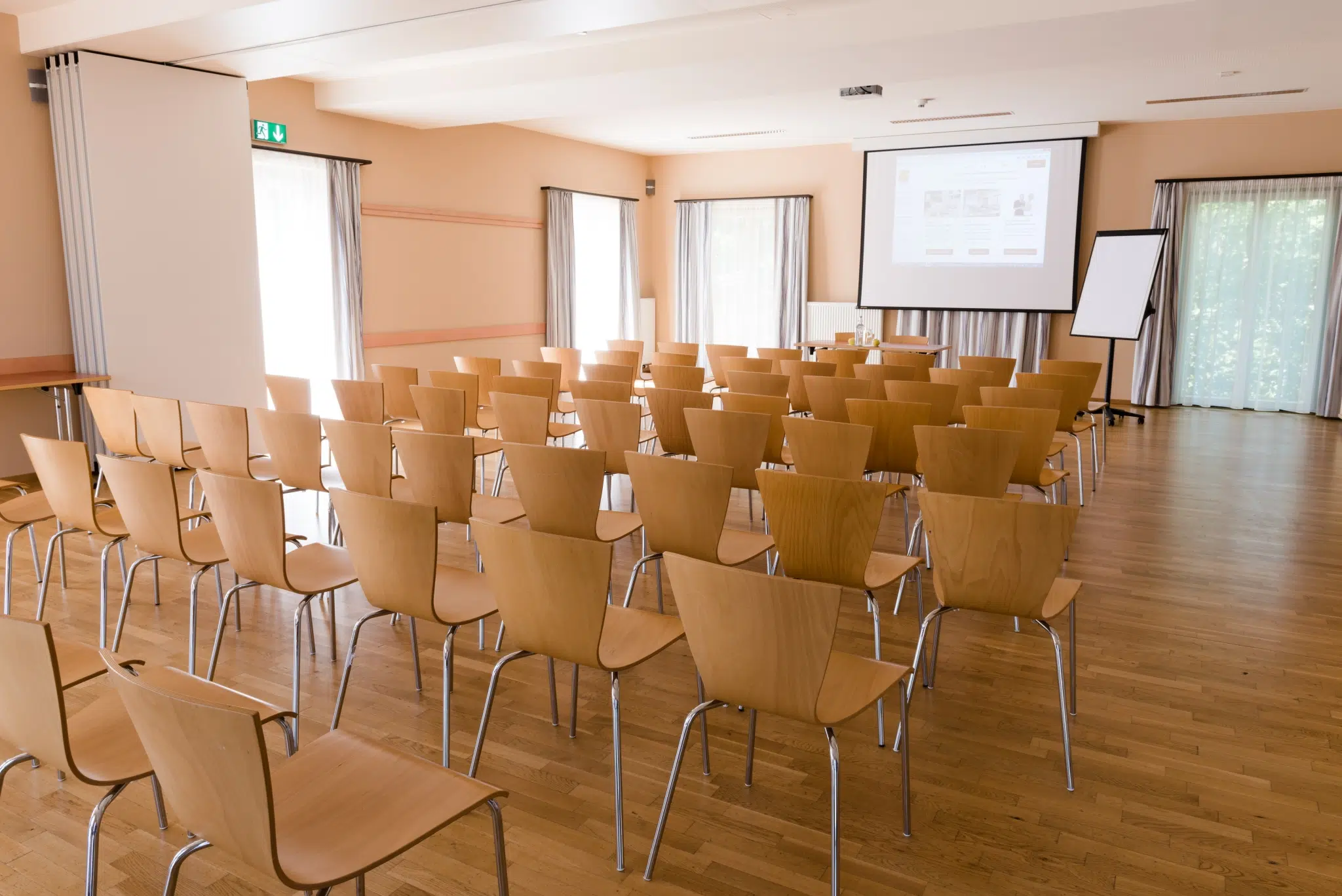 Sie sehen einen gut ausgestatteten Seminarraum im JUFA Hotel Fürstenfeld mit Reihenbestuhlung. JUFA Hotels bietet Ihnen den Ort für erfolgreiches Training in ungezwungener Atmosphäre für Vereine und Teams.