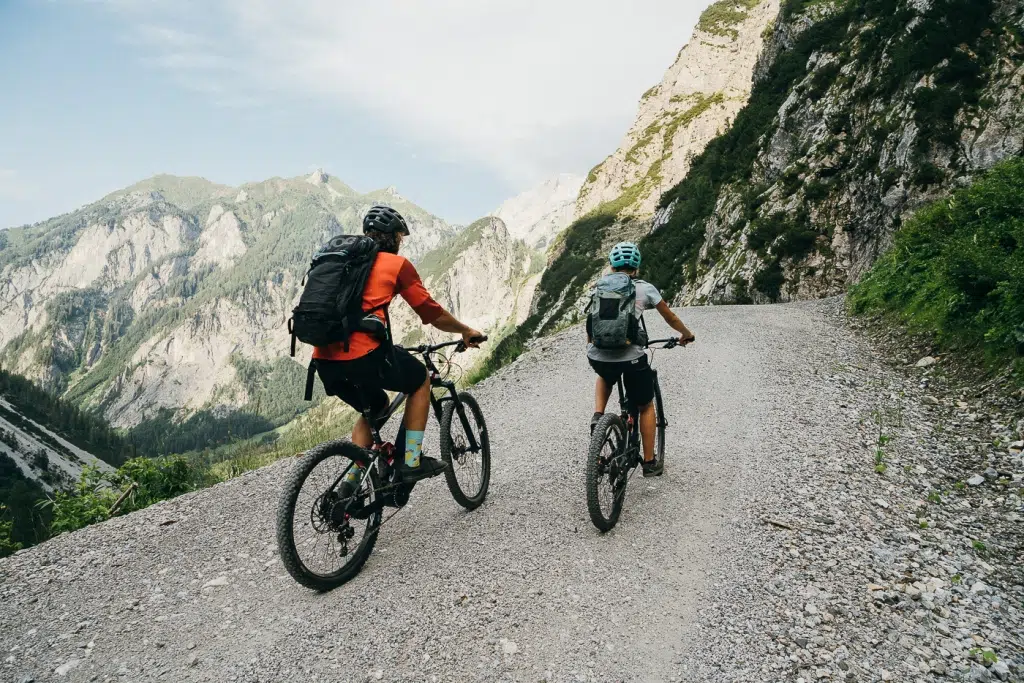 Sie sehen zwei Personen beim Mountainbiken.