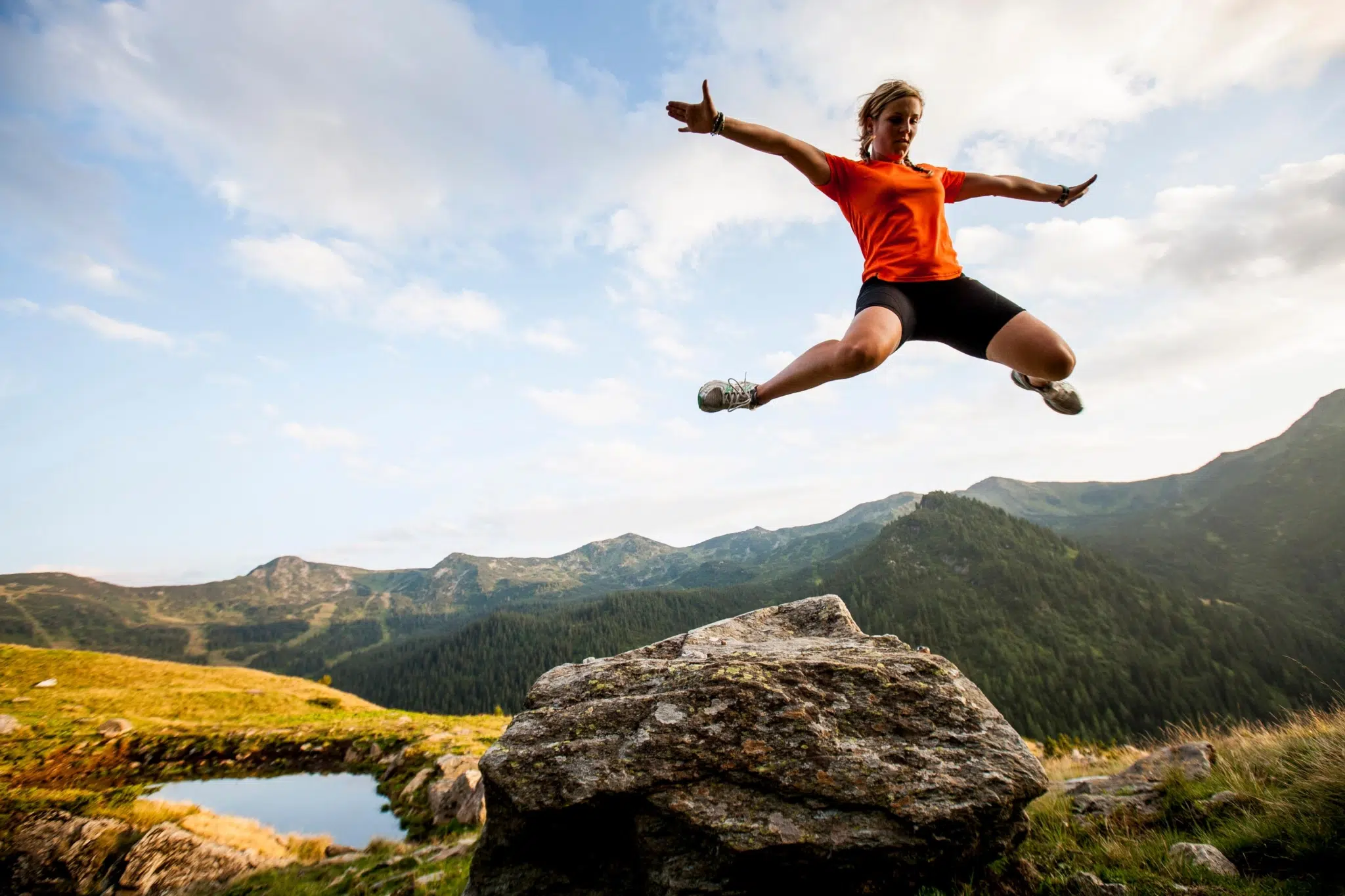 Frau springt auf der Planneralm in die Luft in der Nähe von JUFA Hotels. Der Ort für erholsamen Familienurlaub und einen unvergesslichen Winter- und Wanderurlaub.