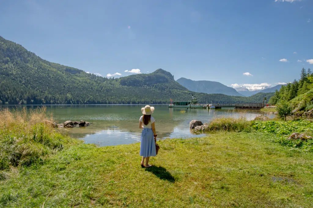 Ihr seht eine Frau am Altausseer See bei herrlichem Sonnenschein im steirischen Salzkammergut.