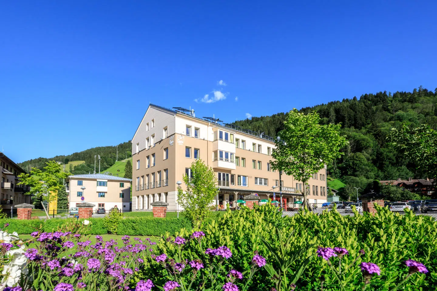 Ihr seht die Außenansicht des JUFA Hotel Schladming*** im Sommer.