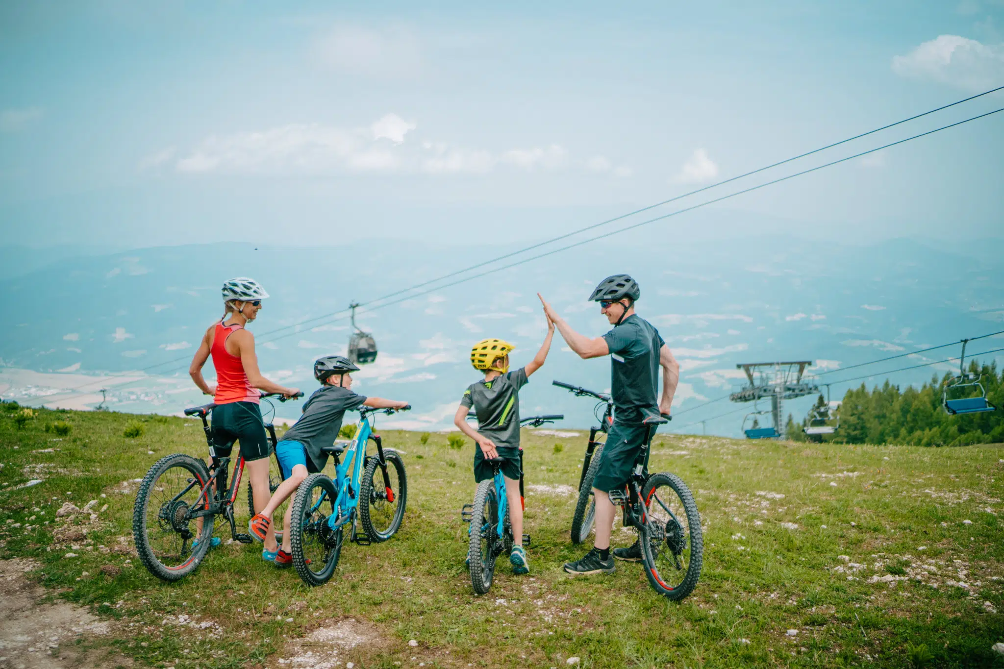 Ihr seht eine Familie beim Biken auf der Petzen mit ihren Mountainbikes.