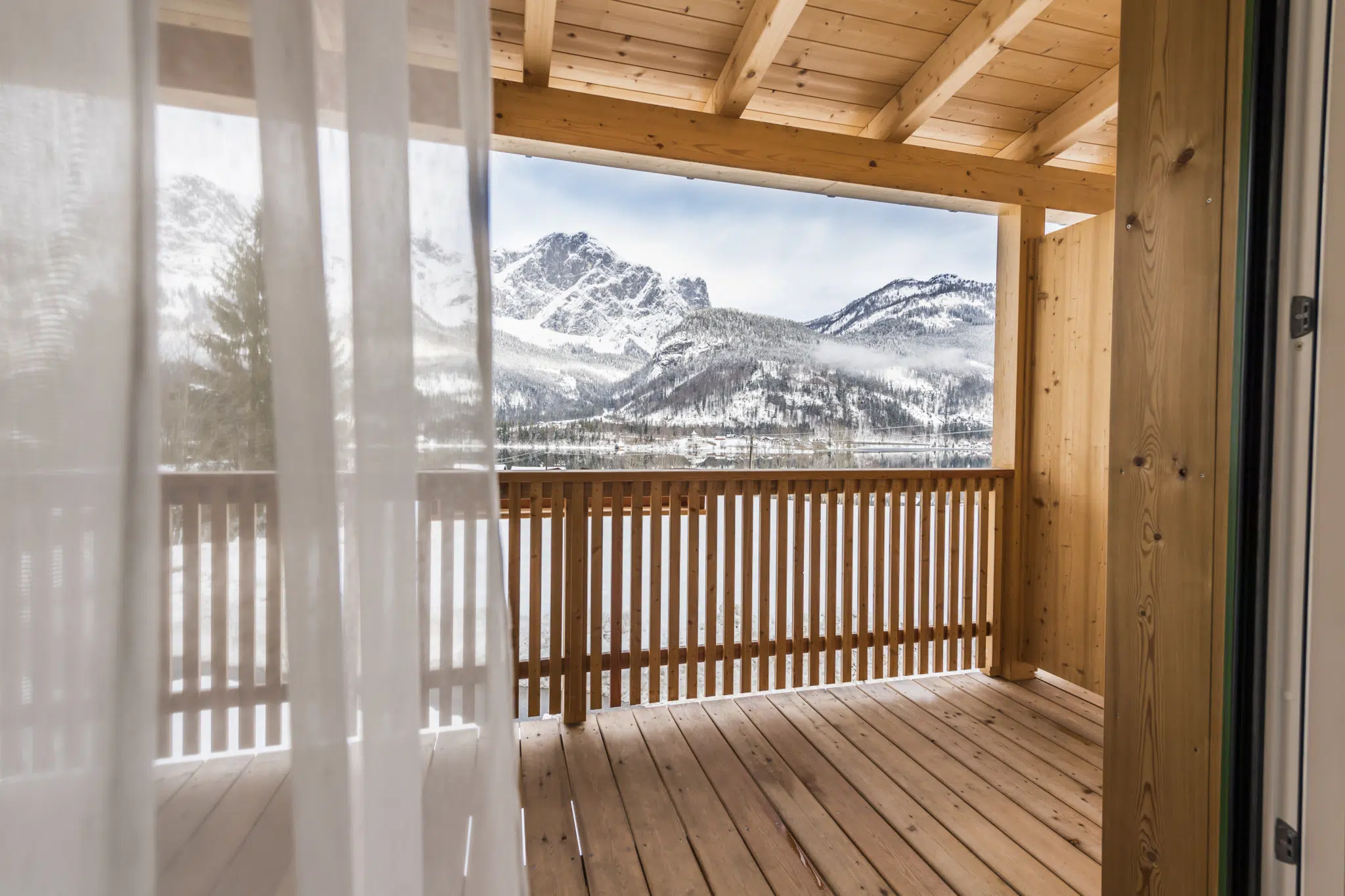 Ihr seht einen Balkon im JUFA Hotel Grundlsee*** mit Bergpanorama im Winter. JUFA Hotels bietet erholsamen Familienurlaub und einen unvergesslichen Winterurlaub.