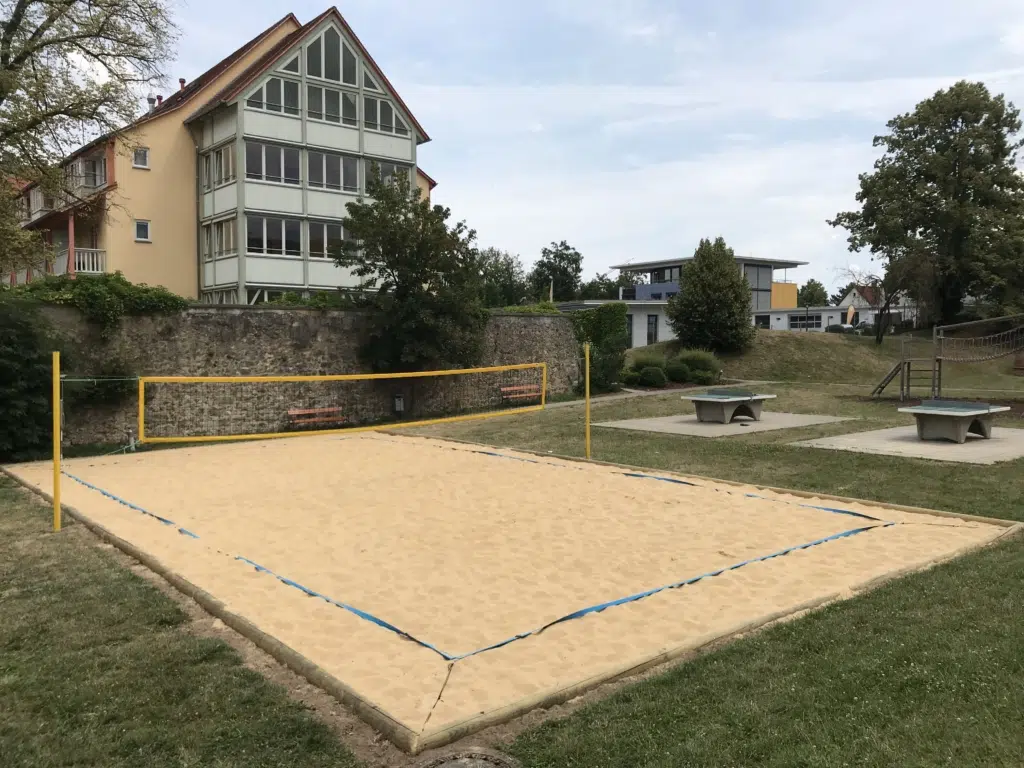 Ihr seht den Beachvolleyballplatz mit Tischtennistischen vom JUFA Hotel Nördlingen***. Der Ort für kinderfreundlichen und erlebnisreichen Urlaub für die ganze Familie.