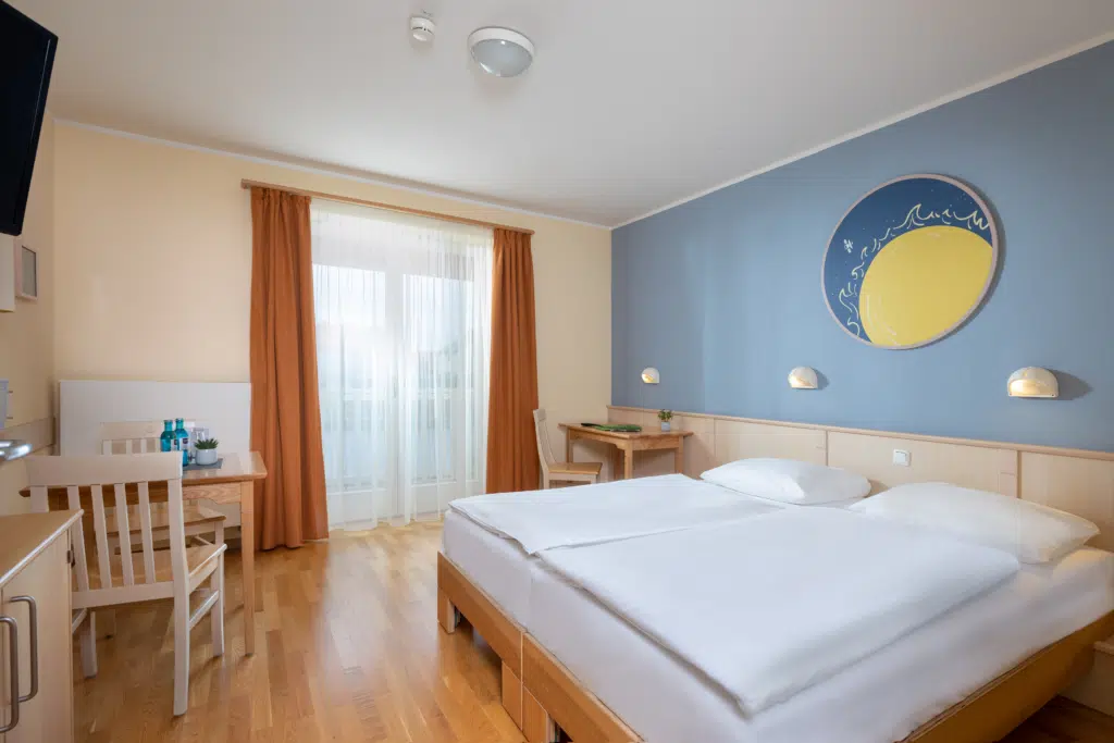 Ihr seht ein Doppelzimmer mit Doppelbett - den Galaxien gewidmet im JUFA Hotel Nördlingen***. Der Ort für kinderfreundlichen und erlebnisreichen Urlaub für die ganze Familie.