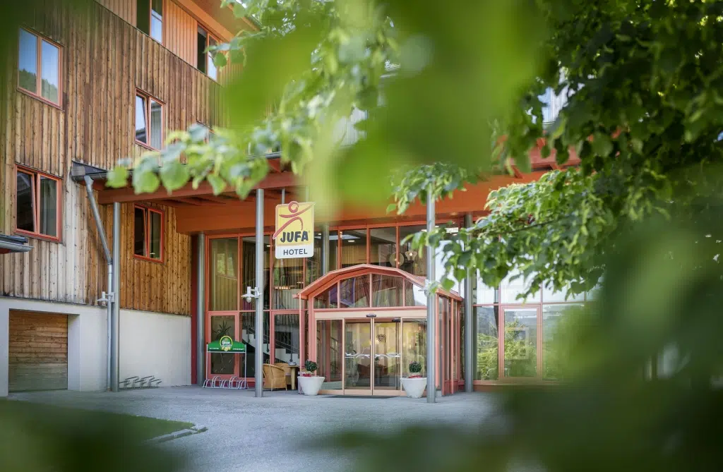 Ihr seht den Eingang zum JUFA Hotel Mariazell***. Der Ort für erholsamen Familienurlaub und einen unvergesslichen Winter- und Wanderurlaub.