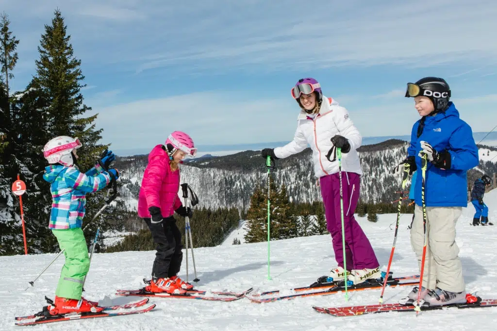 Ihr seht eine Familie beim Skifahren im Skigebiet Annaberg. JUFA Hotels bietet erholsamen Familienurlaub und einen unvergesslichen Winterurlaub.