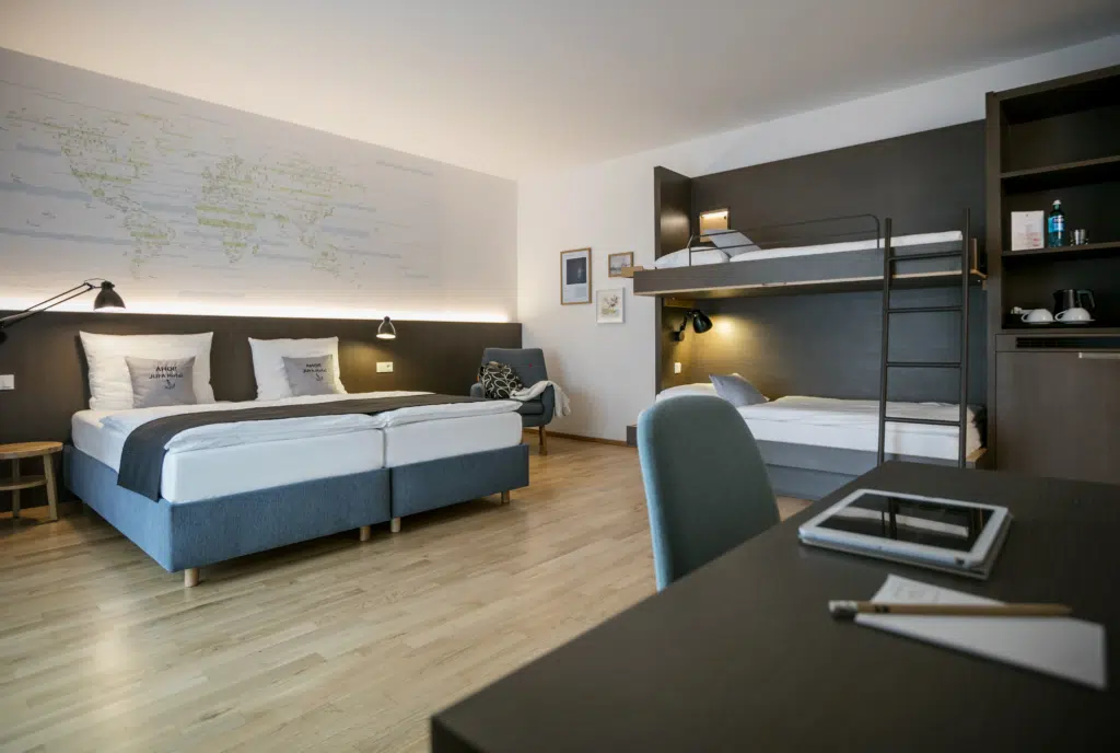 Ihr seht ein Doppelbett im Vierbettzimmer im JUFA Hotel Hamburg HafenCity****. Der Ort für erlebnisreichen Städtetrip für die ganze Familie und der ideale Platz für Ihr Seminar.