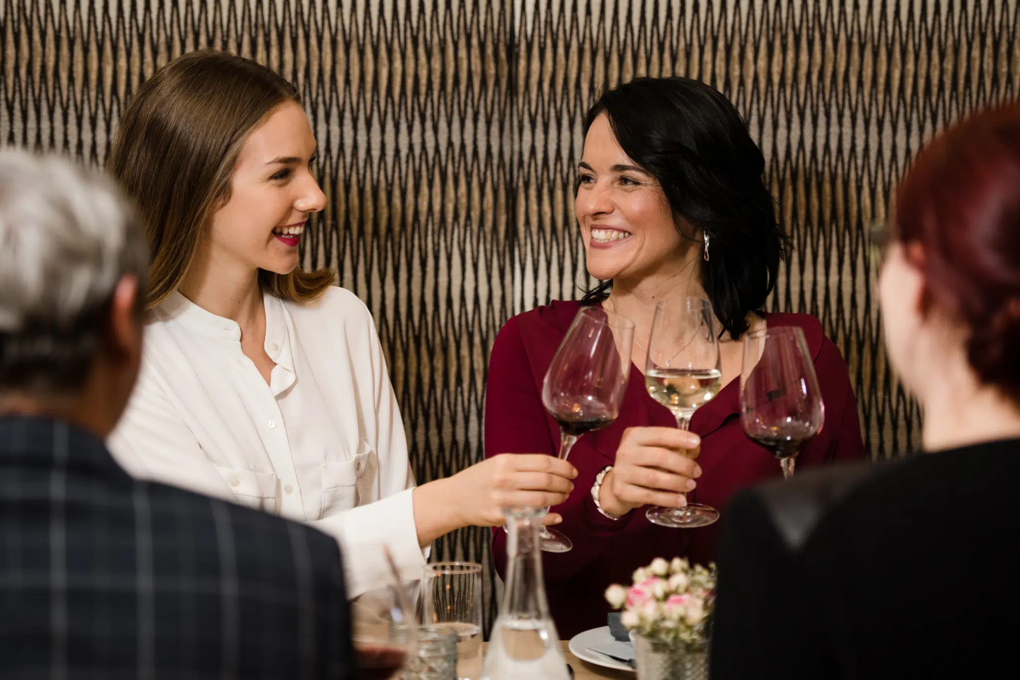 Ihr seht zwei Frauen mit Wein im EventArium am JUFA Hotel Neutal – Landerlebnis. Der Ort für erlebnisreichen Natururlaub für die ganze Familie.