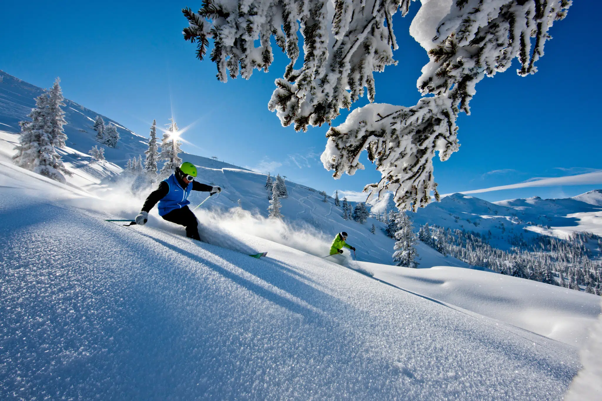 Ihr seht zwei Leute, die im Tiefschnee der Planneralm runterdüsen.