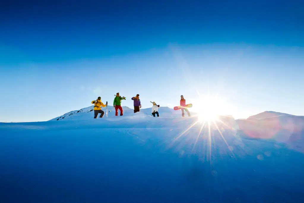 Ihr seht vier Skifahrer*innen und eine Snowboarderin auf der Planneralm.