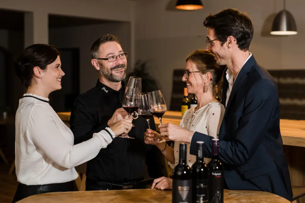 Gäste mit Wein im EventArium am JUFA Hotel Neutal – Landerlebnis. Der Ort für erlebnisreichen Natururlaub für die ganze Familie.