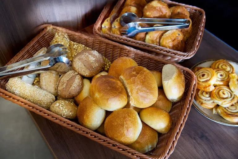 Ihr seht einen Gebäckkorb mit Brötchen am Buffet im JUFA Hotel Festung Rosenberg Kronach***s. Der Ort für kinderfreundlichen und erlebnisreichen Urlaub für die ganze Familie.