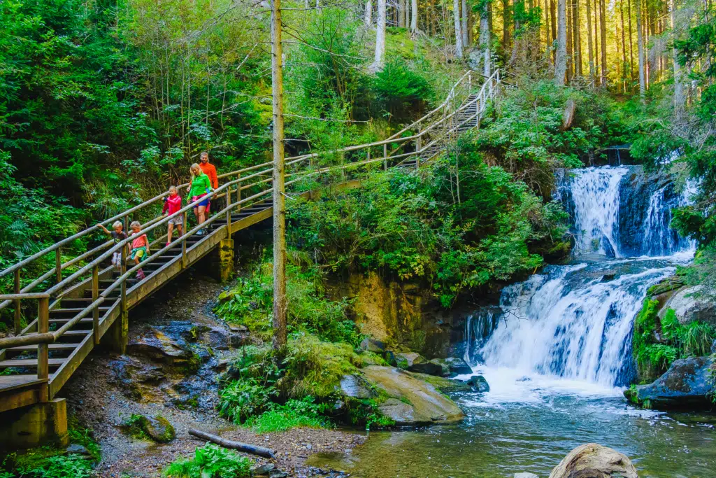 Ihr seht eine Familie beim Wandern entlang der Graggerschlucht im Naturpark Zirbitzkogel-Grebenzen