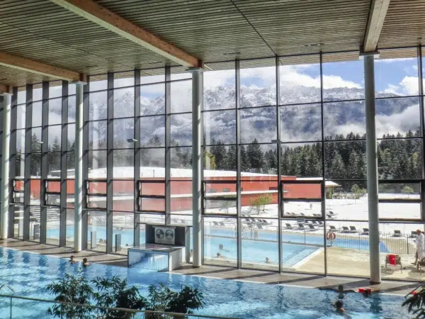 Innenansicht der Therme Grimming mit Fensterfront und Panoramablick in die Winterlandschaft in der Nähe von JUFA Hotels. Der Ort für erholsamen Familienurlaub und einen unvergesslichen Winter- und Wanderurlaub.