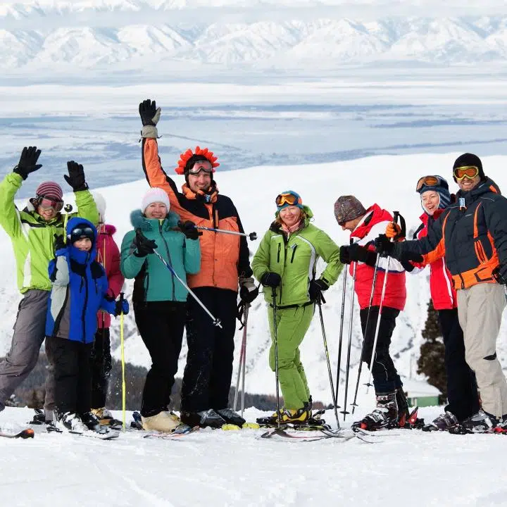 Ihr seht eine Gruppe von Menschen wie sie für ein Gruppenfoto im Skigewand posieren.