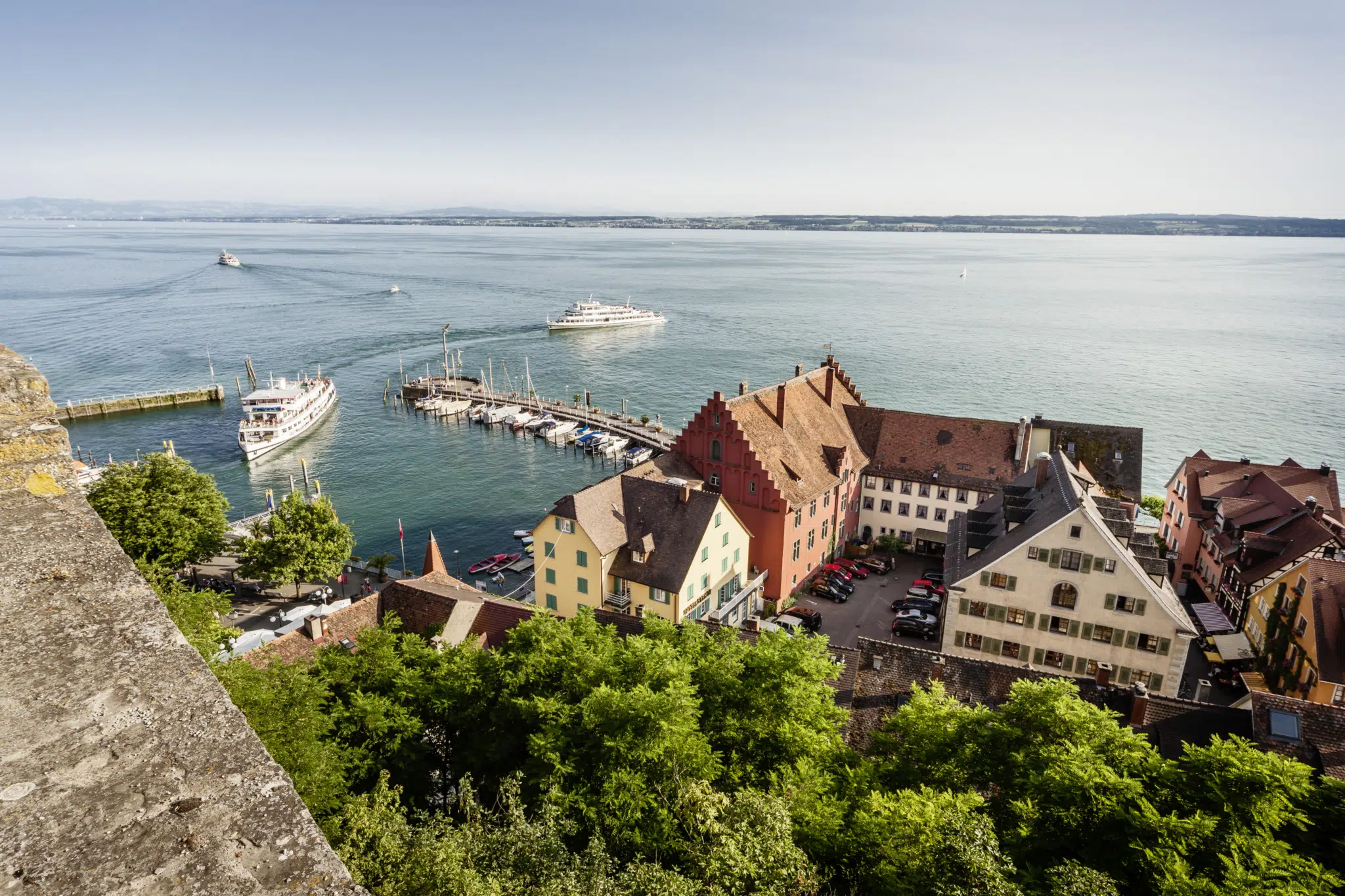 Ihr seht einen Hafen mit Unterstadt in Meersburg. JUFA Hotels, der Ort für erholsamen und eindrucksvollen Sommerurlaub für die ganze Familie.