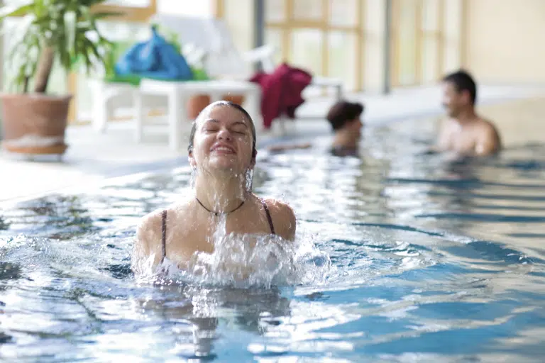 Erwachsene baden im Hallenbad im JUFA Hotel Gnas - Sport-Resort. Der Ort für erfolgreiches Training in ungezwungener Atmosphäre für Vereine und Teams.