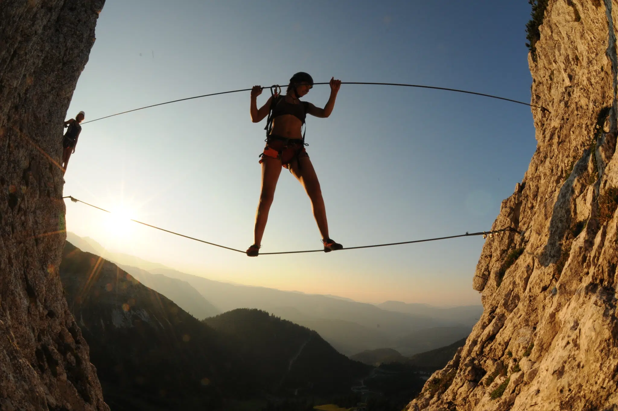 Erwachsene klettert über Schlucht am Heli-Kraft Klettersteig im Hochkar. JUFA Hotels bietet Ihnen den Ort für erlebnisreichen Natururlaub für die ganze Familie.