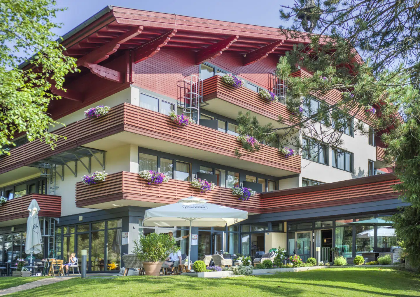 Ihr seht die Außenansicht vom JUFA Hotel Altenmarkt*** von der Wiese aus im Sommer.