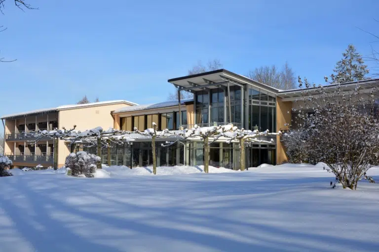 Ihr seht eine Hotelansicht mit Schnee im Winter vom JUFA Hotel Wangen im Allgäu***s. Der Ort für erfolgreiches Training in ungezwungener Atmosphäre für Vereine und Teams.