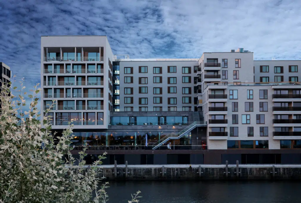 Ihr seht eine Hotelansicht vom JUFA Hotel Hamburg HafenCity**** an der Elbe. Der Ort für erlebnisreichen Städtetrip für die ganze Familie und der ideale Platz für Ihr Seminar.