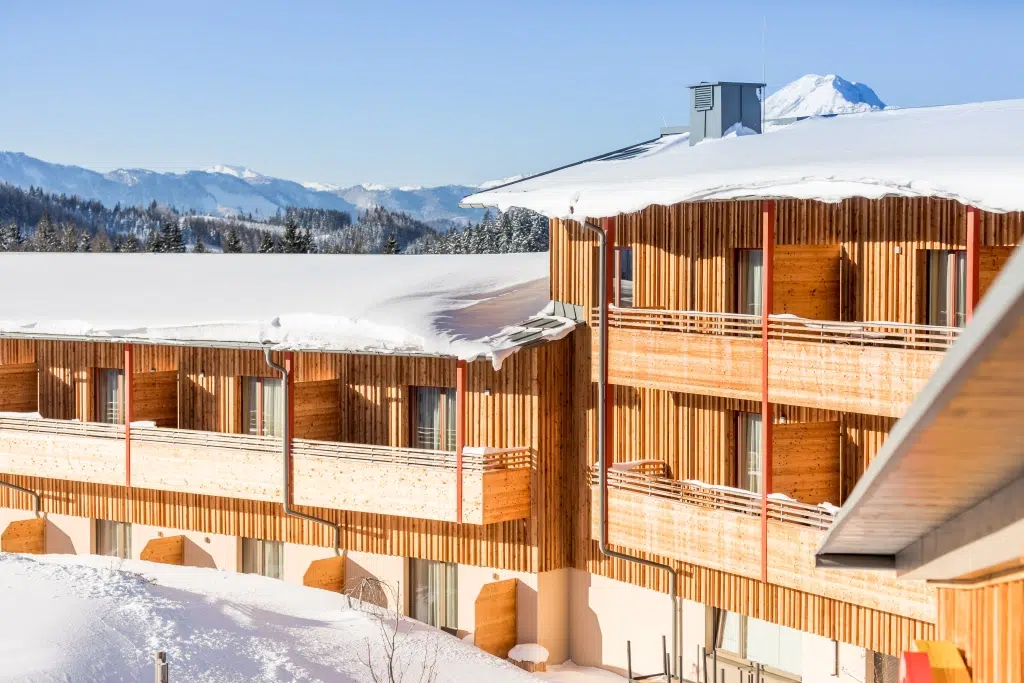 Ihr seht eine Aussenansicht vom JUFA Hotel Annaberg***s mit Balkone im Winter. Der Ort für erholsamen Familienurlaub und einen unvergesslichen Winter- und Wanderurlaub.