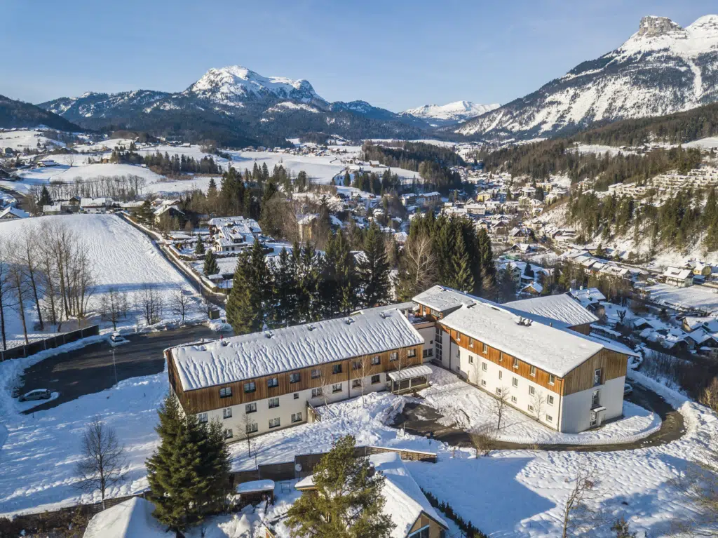 Ihr seht eine Außenansicht vom JUFA Hotel Bad Aussee*** aus der Vogelperspektive im Winter. JUFA Hotels bietet erholsamen Familienurlaub und einen unvergesslichen Winterurlaub.