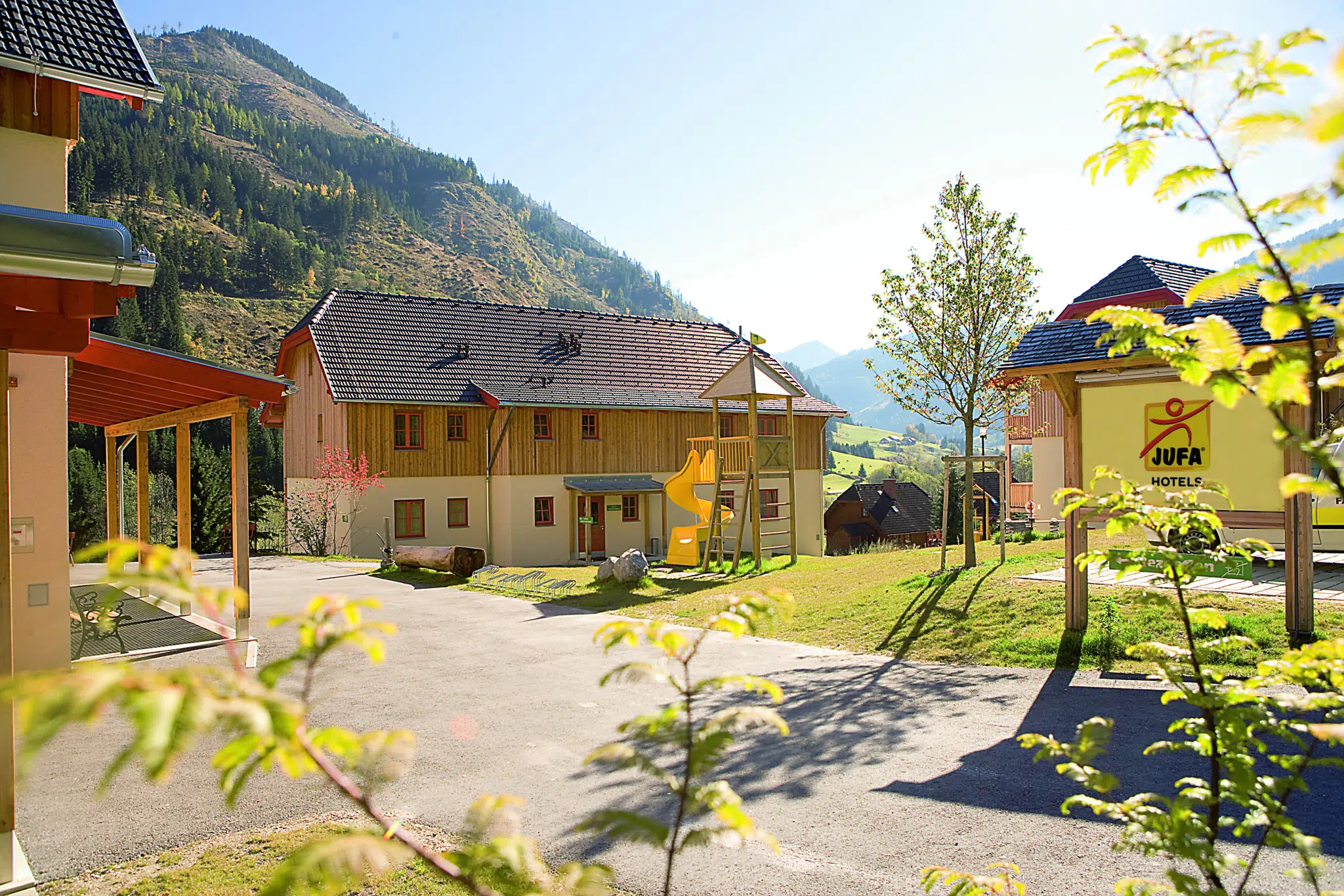 Aussenansicht vom JUFA Hotel Donnersbachwald - Almerlebnis im Sommer. Der Ort für erholsamen Familienurlaub und einen unvergesslichen Winter- und Wanderurlaub.