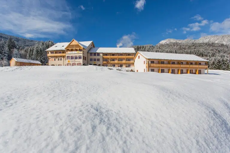 Sie sehen das JUFA Hotel Gitschtal*** von außen im Winter.