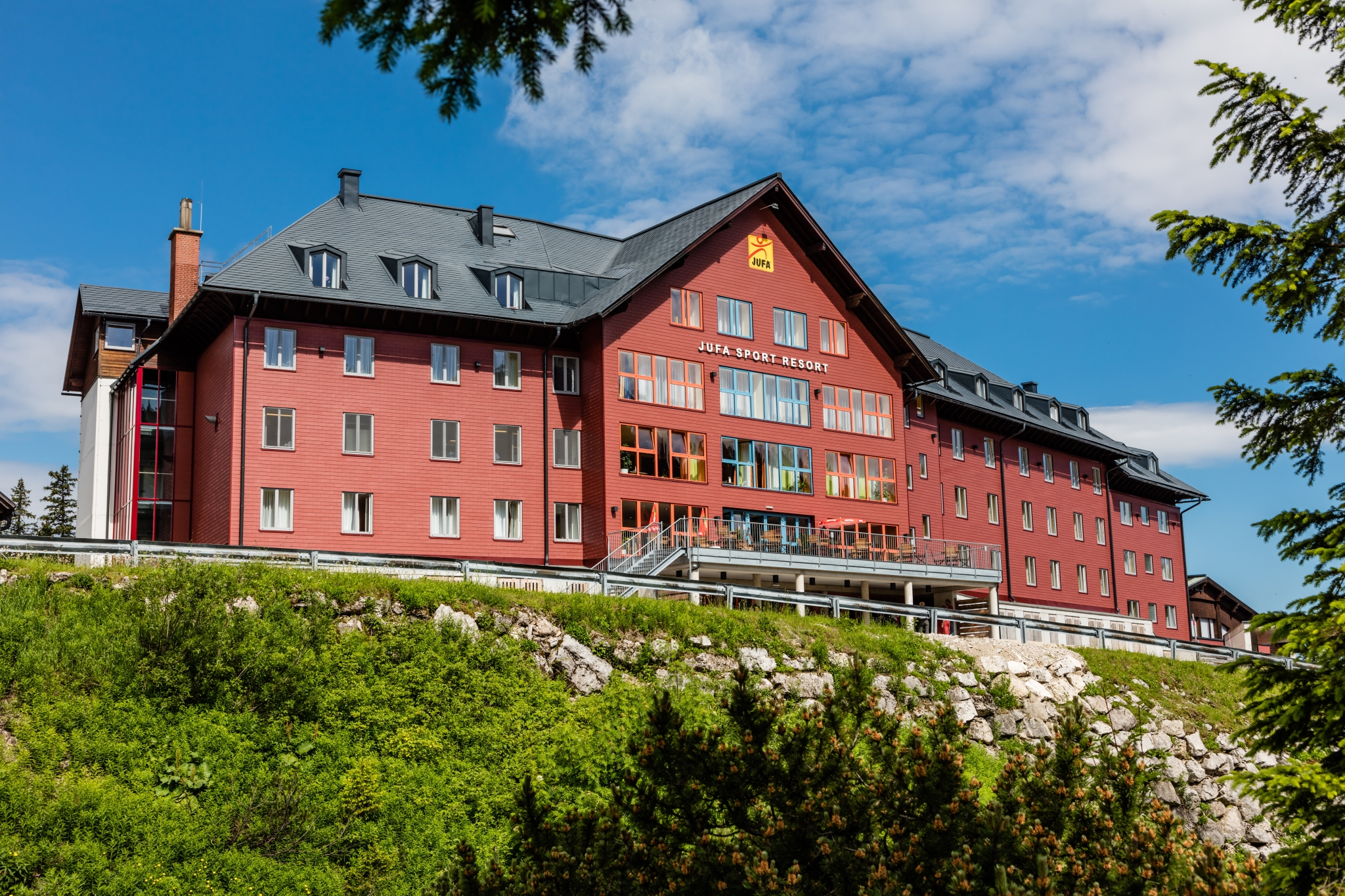 Hotelansicht mit Wiese im Sommer vom JUFA Hotel Hochkar Sport-Resort. Der Ort für erfolgreiches Training in ungezwungener Atmosphäre für Vereine und Teams.