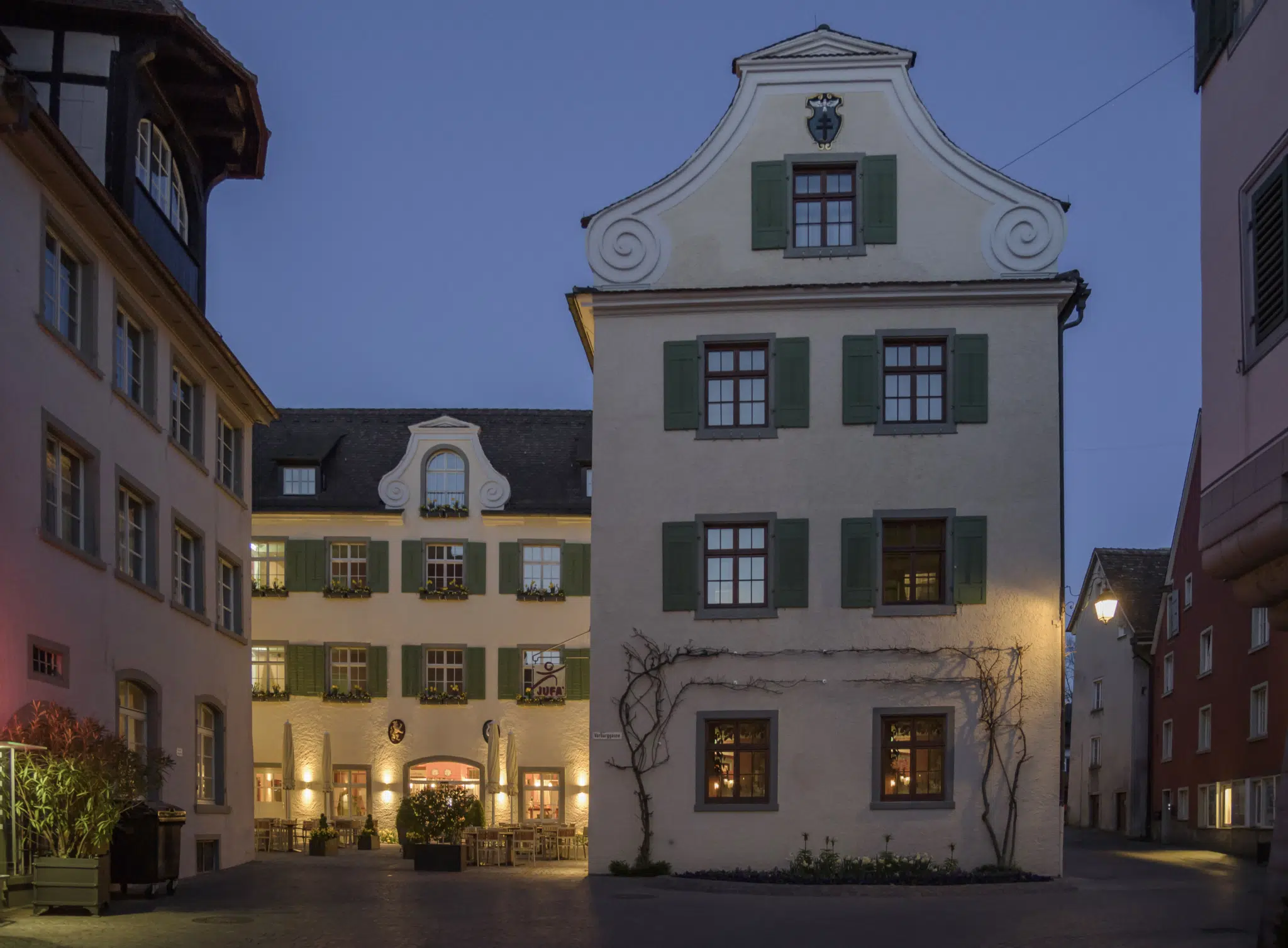 Ihr seht eine Aussenansicht vom JUFA Hotel Meersburg mit Abendstimmung. Der Ort für tollen Sommerurlaub an schönen Seen für die ganze Familie.