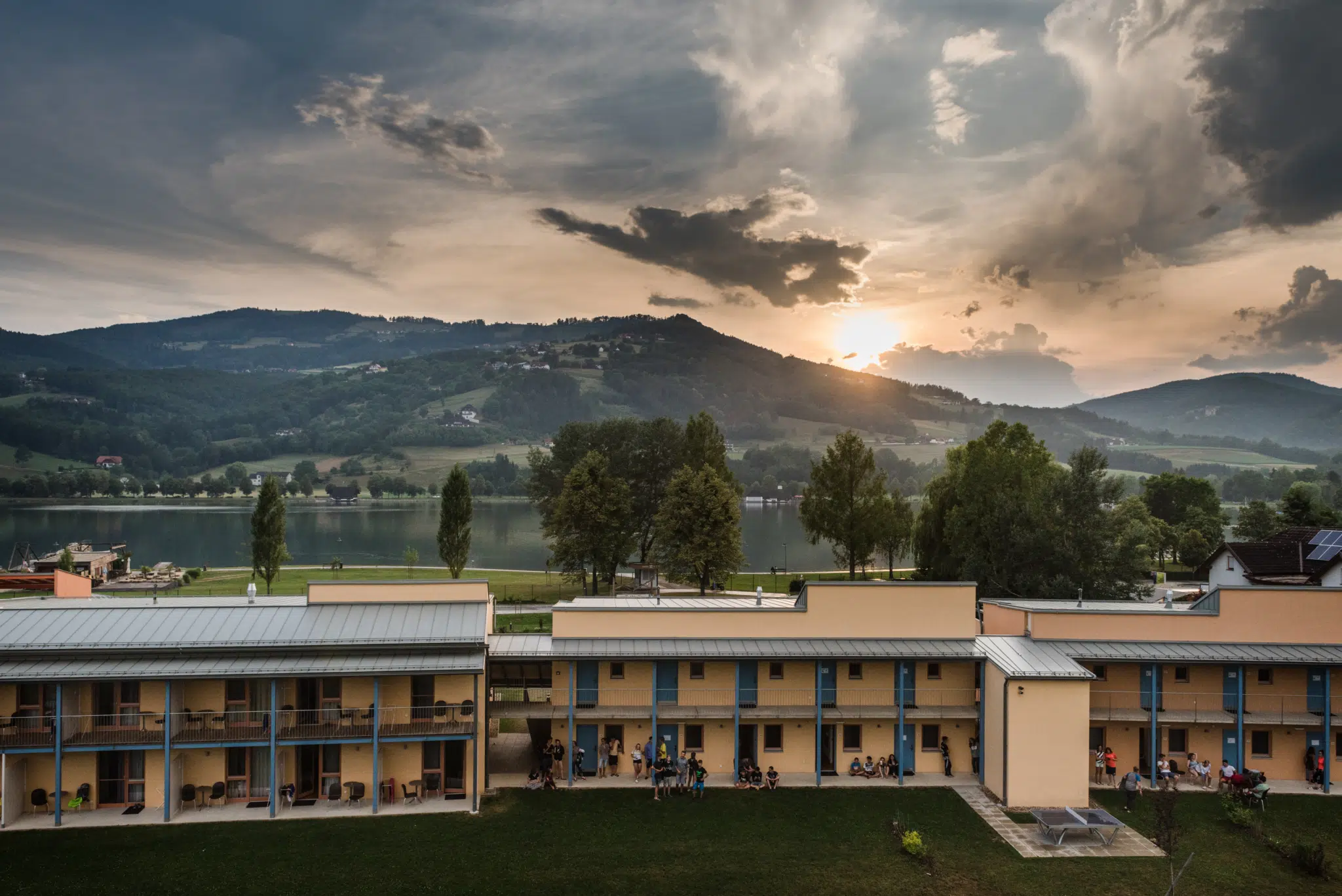 Ihr seht eine Außenansicht vom JUFA Hotel Stubenbergsee mit Seeblick im Sommer. JUFA Hotels bietet kinderfreundlichen und erlebnisreichen Urlaub für die ganze Familie.