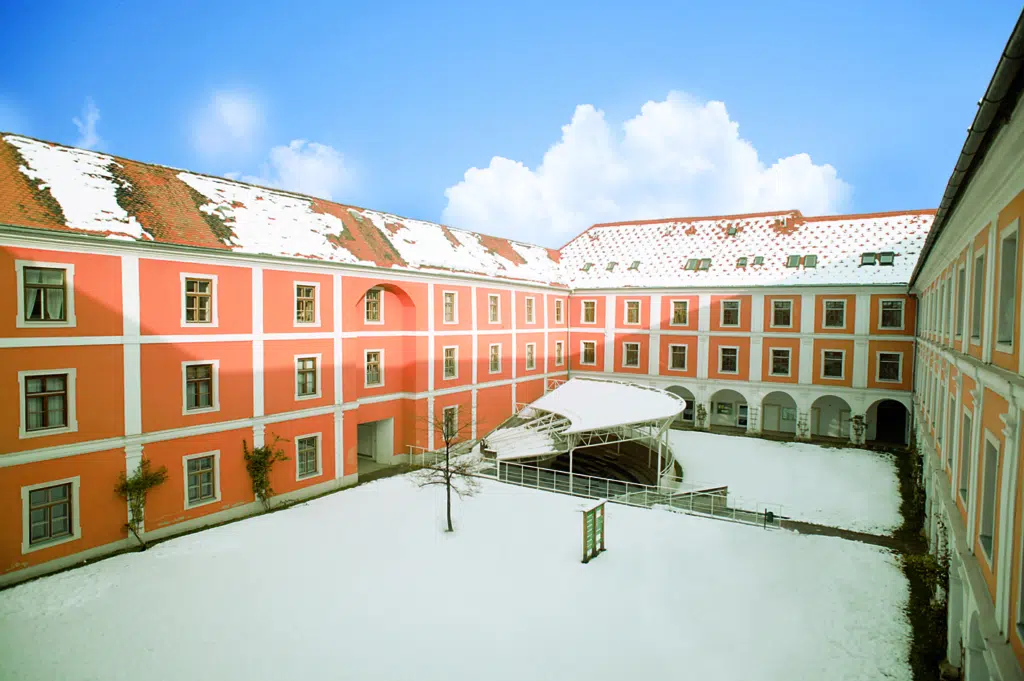 Außenansicht mit Innenhof im Winter vom JUFA Hotel Judenburg. Der Ort für erfolgreiche und kreative Seminare in abwechslungsreichen Regionen.