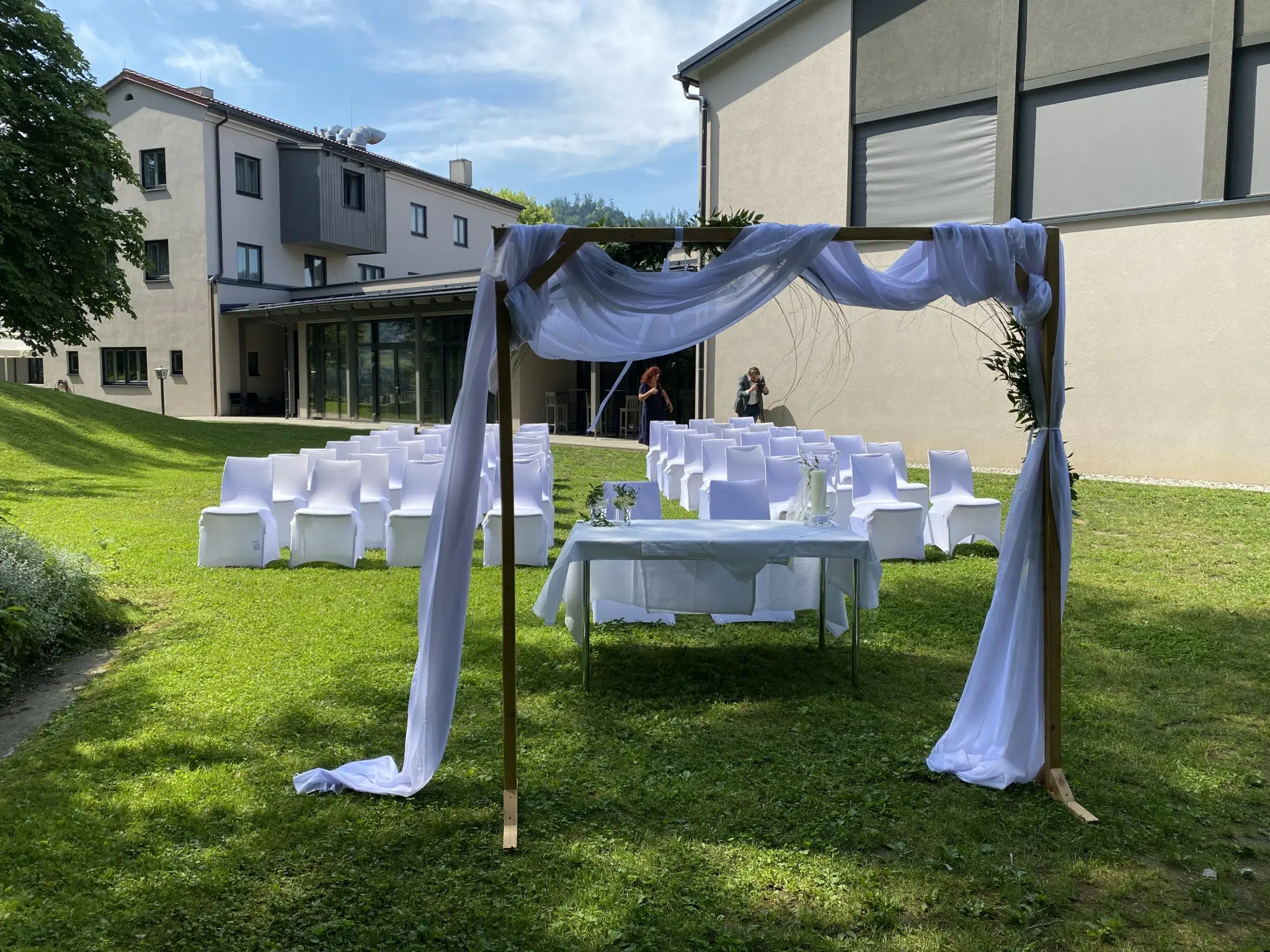 Ihr seht Stühle und einen Bogen für eine Hochzeit im JUFA Hotel Lipizzanerheimat*** in Maria Lankowitz.