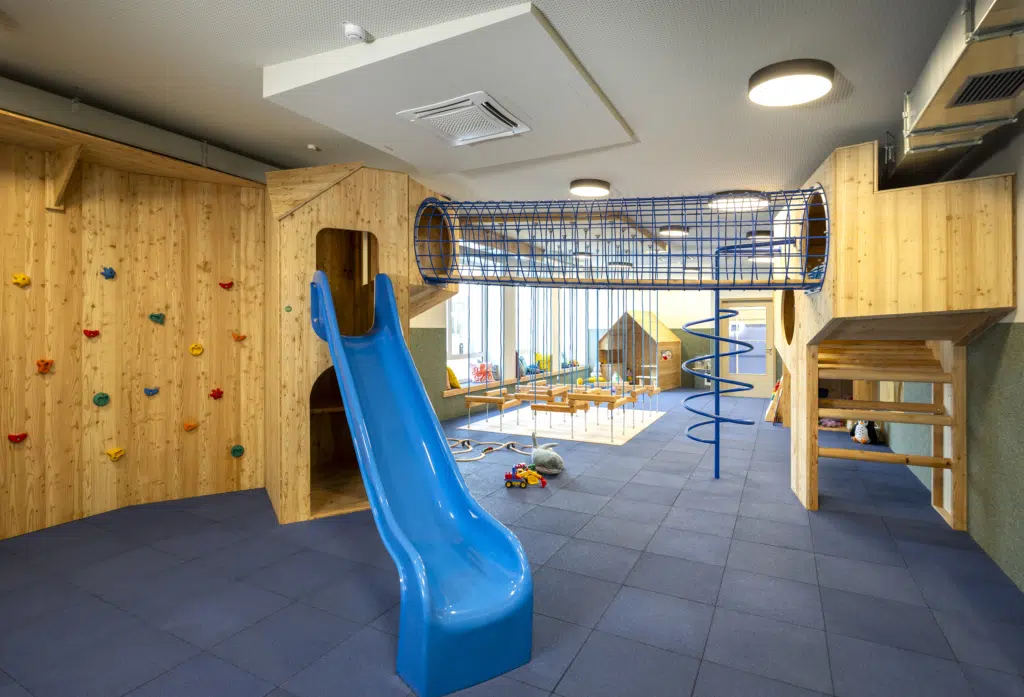 Ihr seht den Indoor-KInderspielbereich im JUFA Hotel Bad Radkersburg mit Rutsche, Boulderwand, zahlreichen Kletter und Krabbelmöglichkeiten und vieles mehr für unseren kleinen Urlaubsgäste.