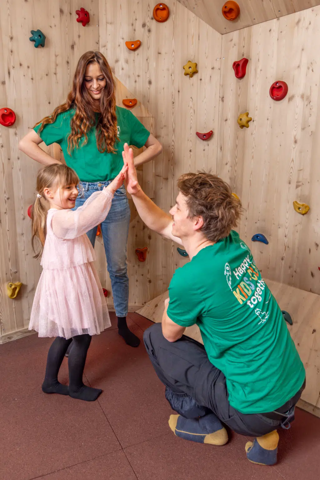 Ihr seht zwei Personen vom Kids Club der JUFA Hotels mit einem kleinen Mädchen im Spielbereich des JUFA Alpenhotels Saalbach****. Der Ort für einen erholsamen Familienurlaub und unvergessliche Wander- und Winterurlaube.