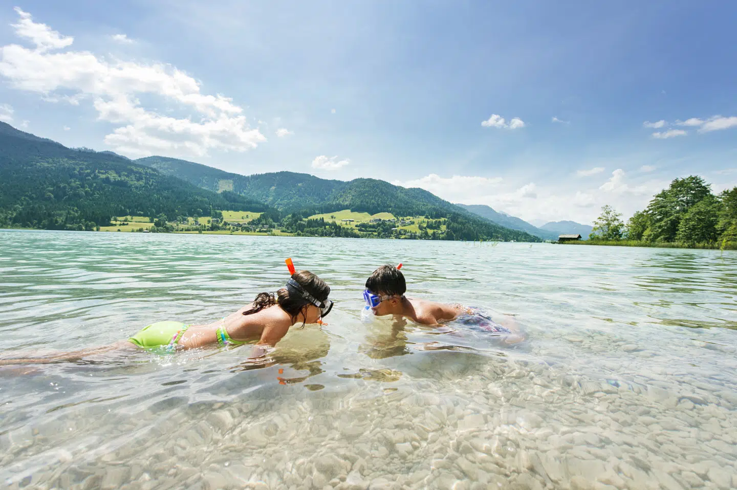 Sie sehen Kinder beim Schnorcheln am Weissensee. JUFA Hotels bietet tollen Sommerurlaub an schönen Seen für die ganze Familie.