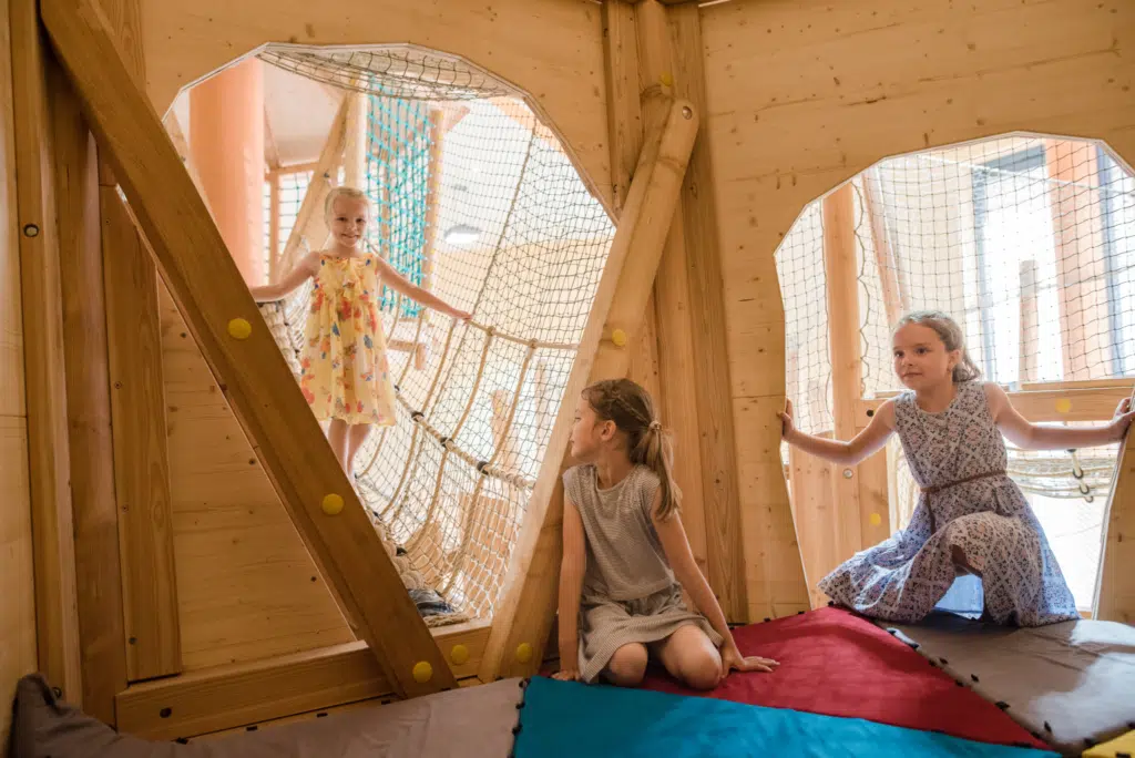 Ihr seht Kinder im Spielhaus im Indoorspielbereich im JUFA Hotel Stubenbergsee. Der Ort für kinderfreundlichen und erlebnisreichen Urlaub für die ganze Familie.