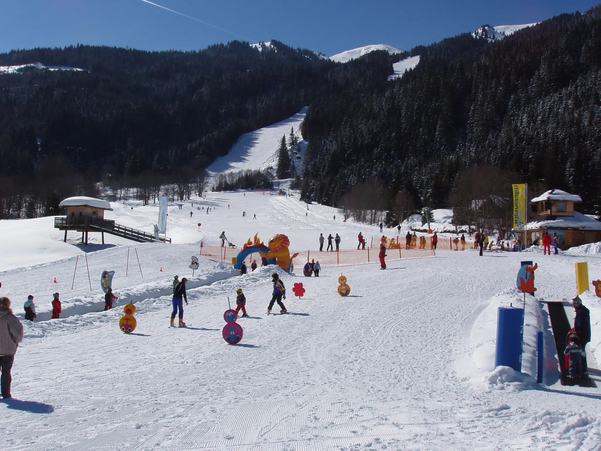 Kinder lernen das Skifahren in der Kinderskischaukel im Skigebiet Riesneralm. JUFA Hotels bietet erholsamen Familienurlaub und einen unvergesslichen Winterurlaub.