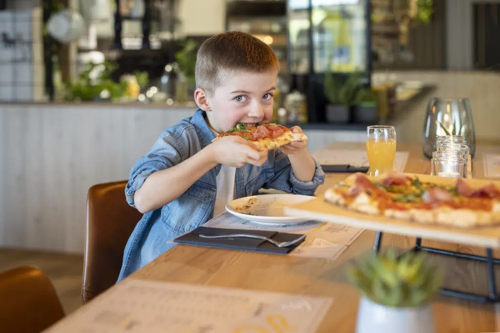 Sie sehen ein Kind, das eine Pizza genießt. Das JUFA Hotel Wipptal ist der ideale Ausgangspunkt für einen erlebnisreichen Urlaub.