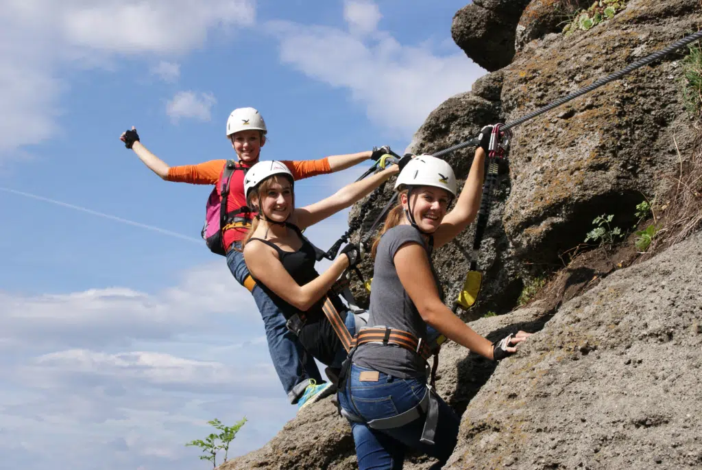 Ihr seht Kletterinnen im Hochseilgarten Riegersburg in der Steiermark. JUFA Hotels bietet erholsamen Familienurlaub und einen unvergesslichen Wanderurlaub.