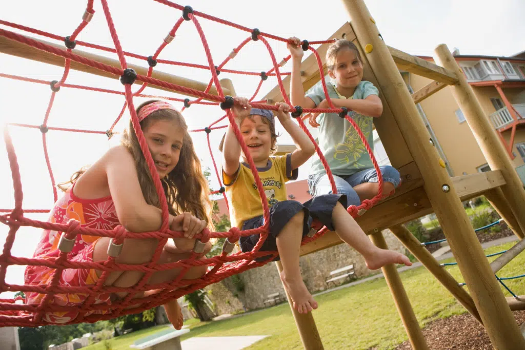 Ihr seht Kinder auf einem Kletternetz im Sommer am JUFA Hotel Nördlingen***. Der Ort für kinderfreundlichen und erlebnisreichen Urlaub für die ganze Familie.