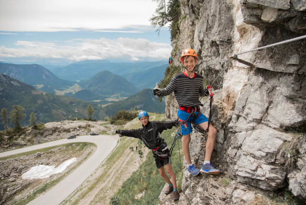 Zwei Jungs klettern am Klettersteig Sophie am Loser in Altaussee. JUFA Hotels bietet Ihnen den Ort für erlebnisreichen Natururlaub für die ganze Familie.