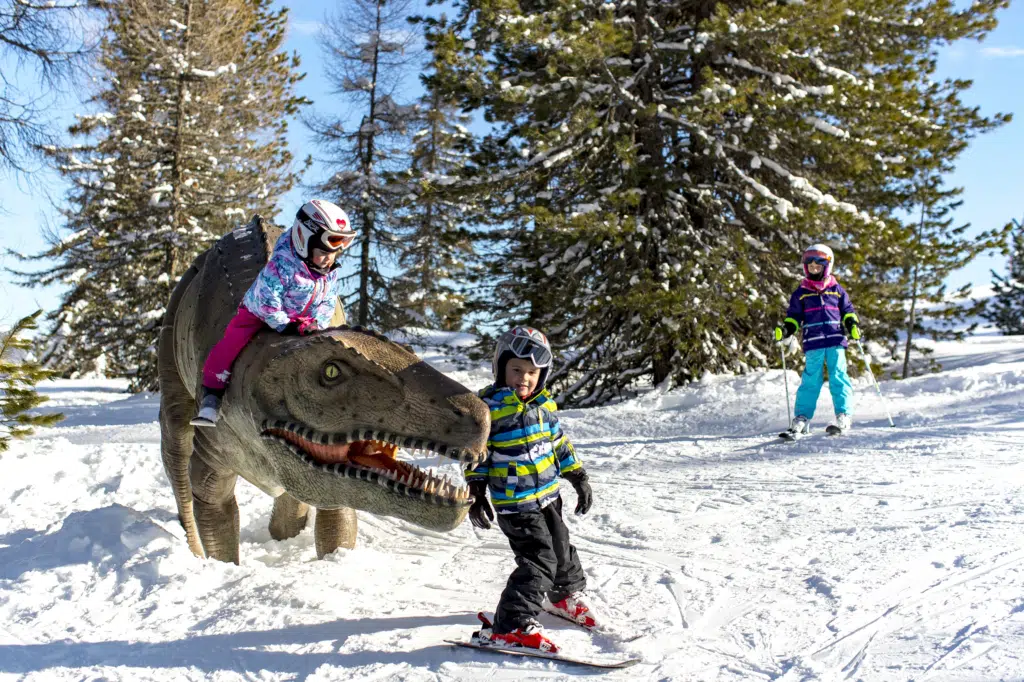 Ihr seht mehrere Kinder beim Skifahren im Dinowald am Kreischberg in der Nähe vom JUFA Hotel Murau***.