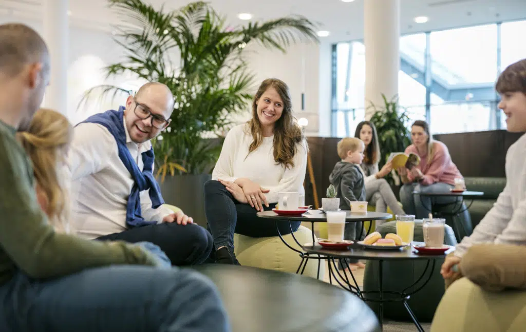 Ihr seht eine Familie und Freunde bei einem Kaffee im JUFA Hotel Hamburg HafenCity****. Der Ort für erlebnisreichen Städtetrip für die ganze Familie und der ideale Platz für Ihr Seminar.