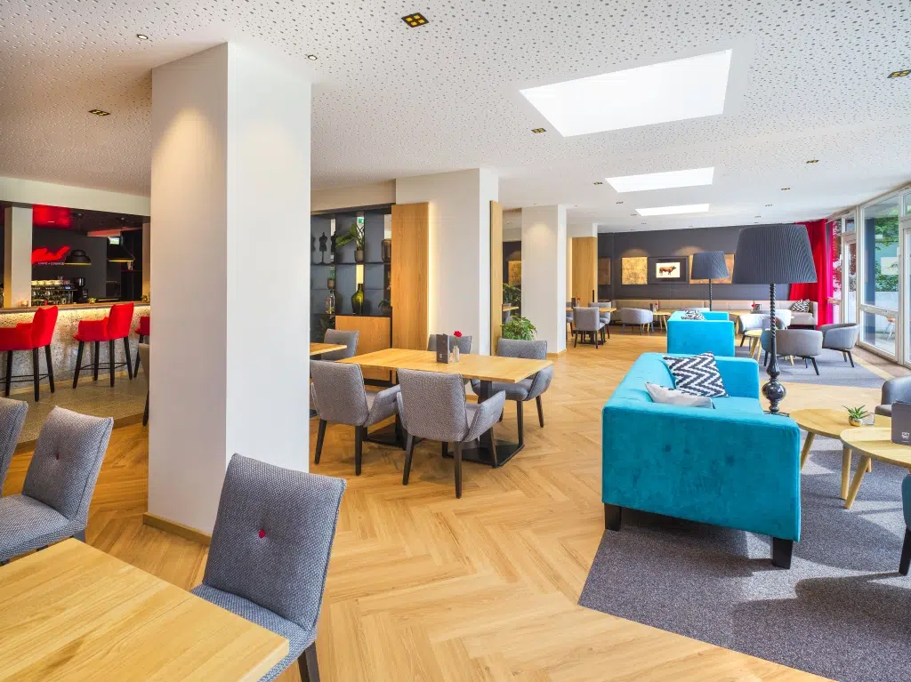 Ihr seht eine Lounge mit Sesseln im JUFA Hotel Salzburg City. Der Ort für erholsamen Familienurlaub und einen unvergesslichen Winter- und Wanderurlaub.