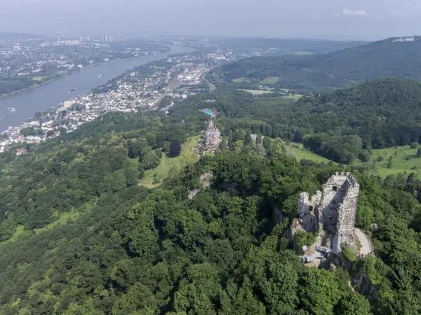 Ihr seht eine Luftaufnahme des Drachenfels mit Blick auf die Burgruine Drachenfels, den Rhein und Königswinter. JUFA Hotels bietet erlebnisreiche Städtetrips für die ganze Familie und den idealen Platz für Ihr Seminar.