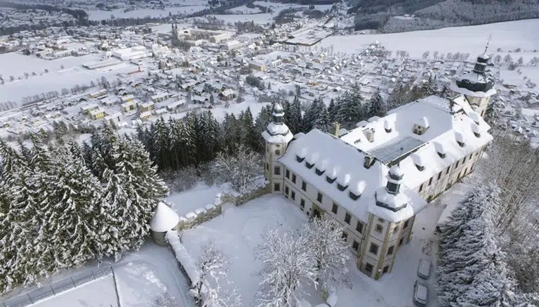 Ihr seht das JUFA Hotel Schloss Röthelstein/Admont*** mit Winterlandschaft in einer Luftaufnahme. JUFA Hotels bietet erholsamen Familienurlaub und einen unvergesslichen Winter- und Wanderurlaub.