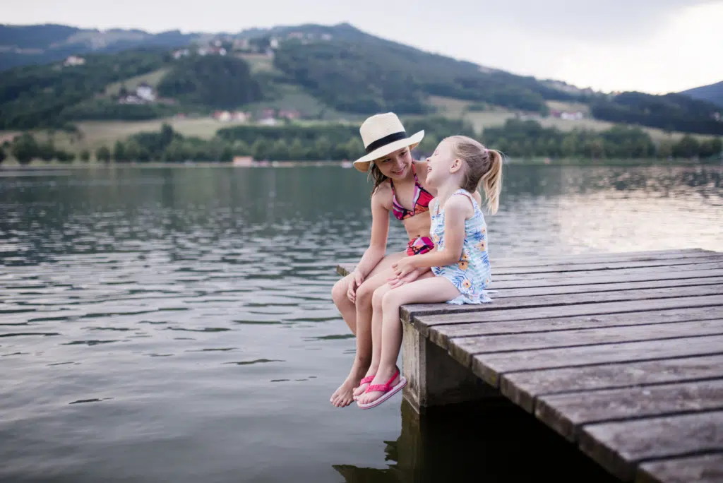 Mädchen auf einem Steg am Stubenbergsee in Badekleidung im Sommer